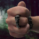 bronze skull paper-weight ring on hand